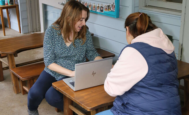 Emma and educator at child sized table with laptop