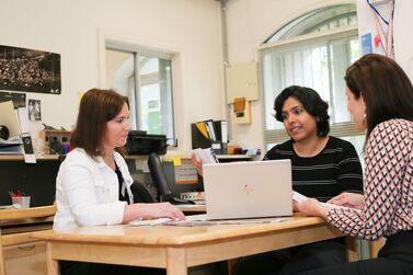 Mika educator and Nicky at table with laptop