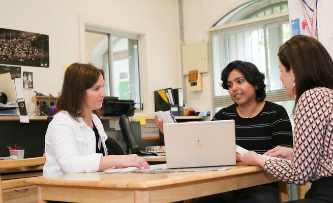 Mika educator and Nicky at table with laptop