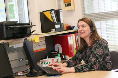 Emma on computer with headphones