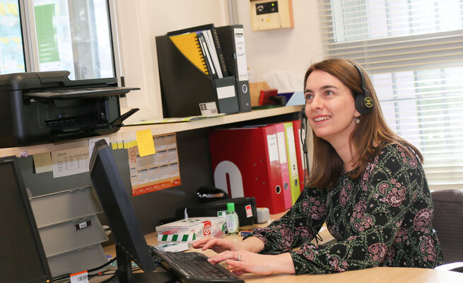 Emma on computer with headphones